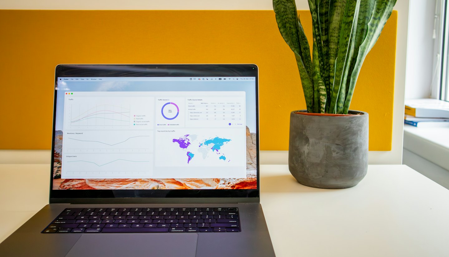 Laptop screen showing business analytics dashboards and world map.